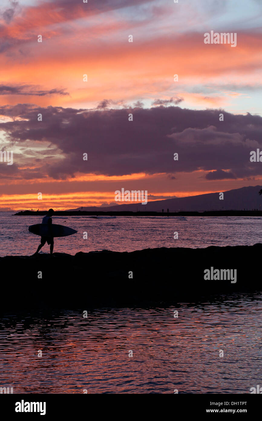 Sonnenuntergang, Surfer auf seinem Weg nach Hause, Waikiki, Honolulu, O'ahu, Hawaii, USA Stockfoto
