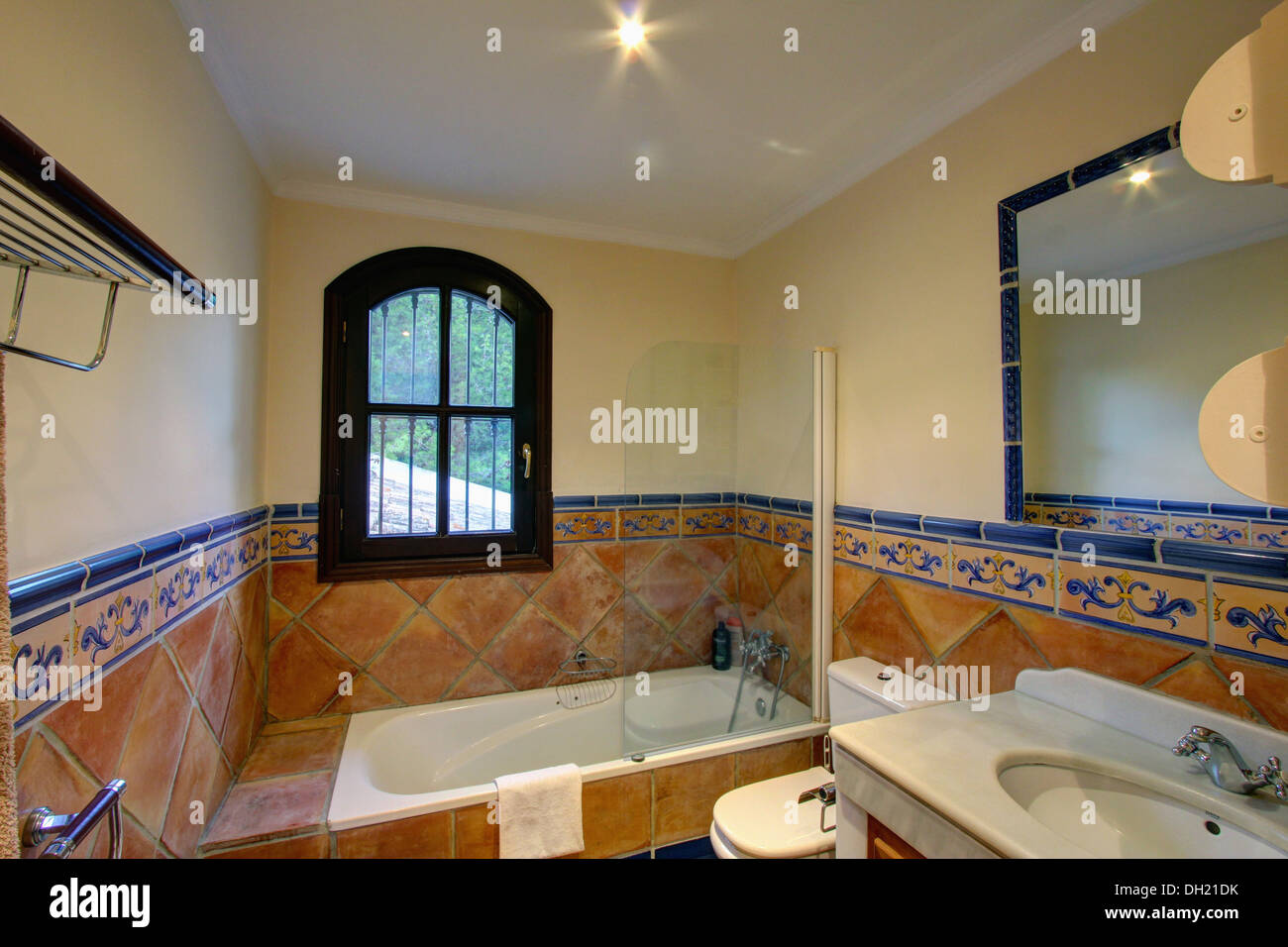 Fenster über Bad im spanischen Badezimmer mit traditionellen Terrakotta Wandfliesen, Höhe dado Stockfoto