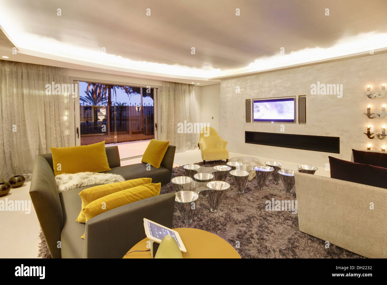 Gelbe Samtkissen auf graue Sofas in großen modernen spanischen Wohnzimmer bei Shag Haufen Teppich und Chrom-Tabellen Stockfoto