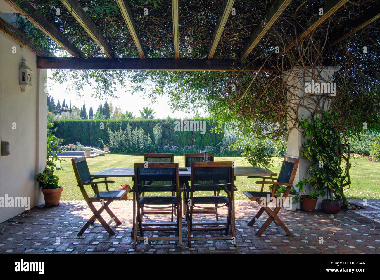 Bergsteiger auf Holz-Pergola über Terrakotta geflieste Terrasse mit