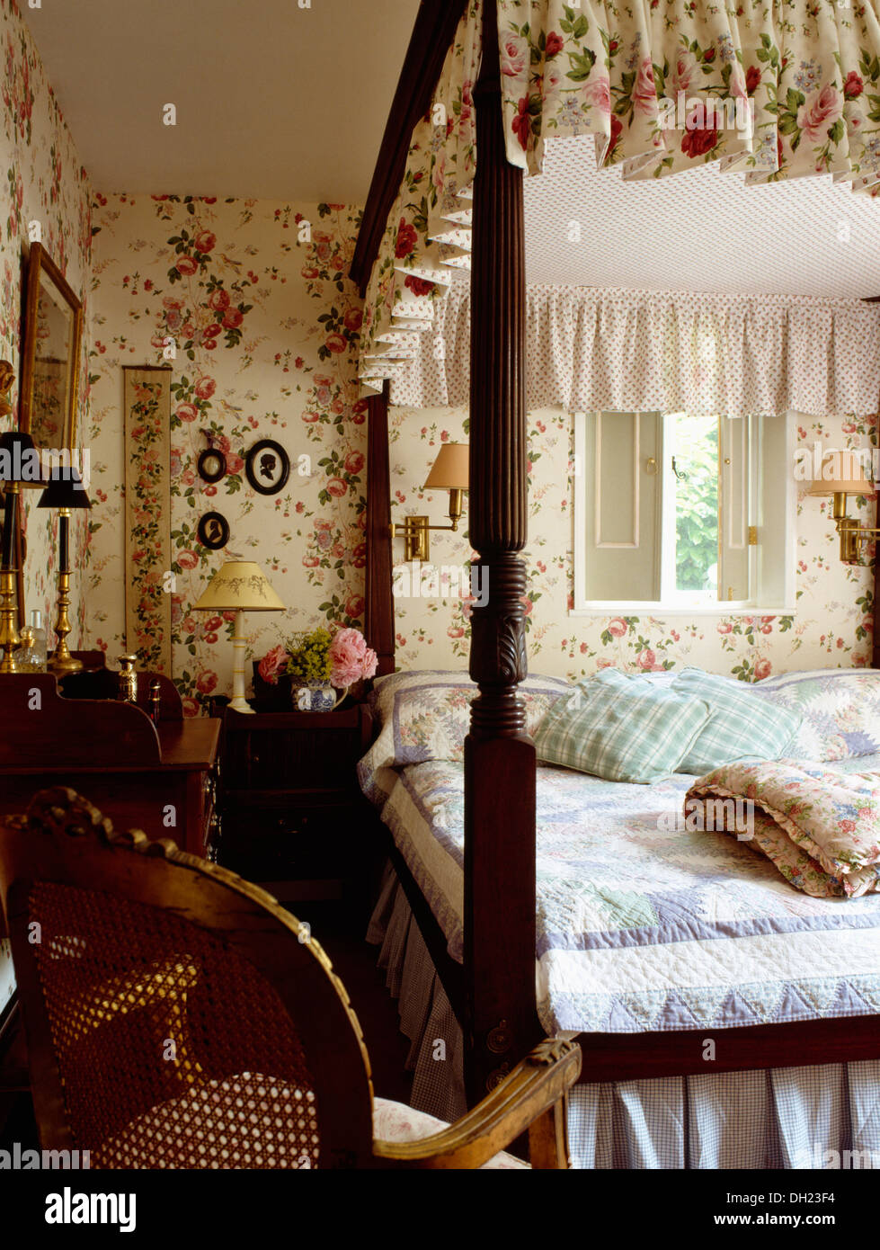 Floral Gardinen und blauen Patchwork quilt auf Himmelbett im Ferienhaus  Schlafzimmer mit passendem Blumentapete und Zuckerrohr Stuhl zurück  Stockfotografie - Alamy