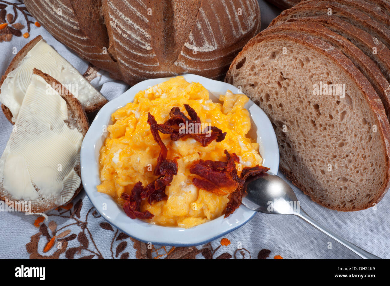 Eiern - Rührei mit Sonne trocknen Tomaten, Brot und butter Stockfoto