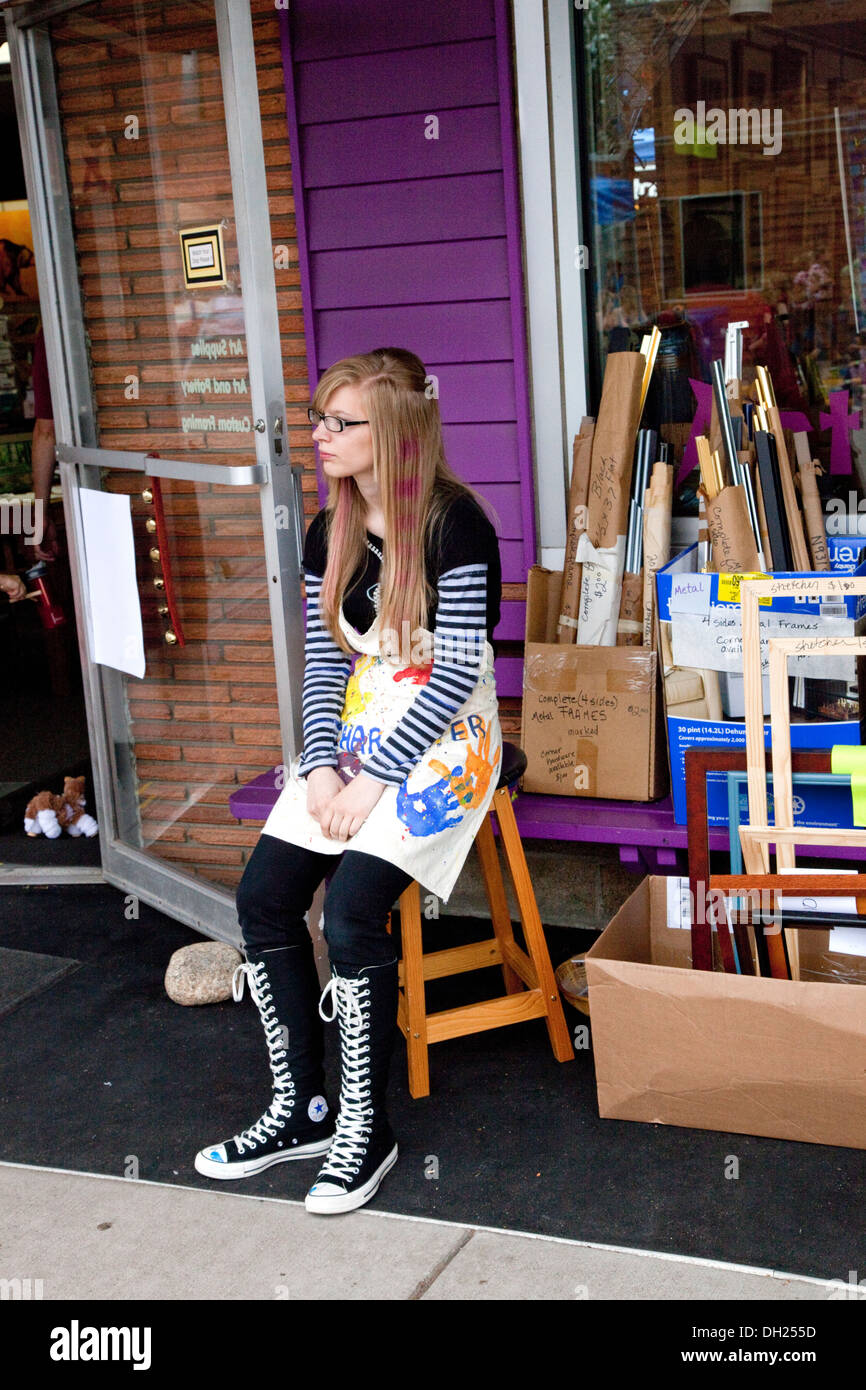 Künstlerische junge Frau sitzt durch ihre Frame-Shop Schuhe high Top Converse Chuck Taylor einen Stern. Hayward Wisconsin WI, USA Stockfoto