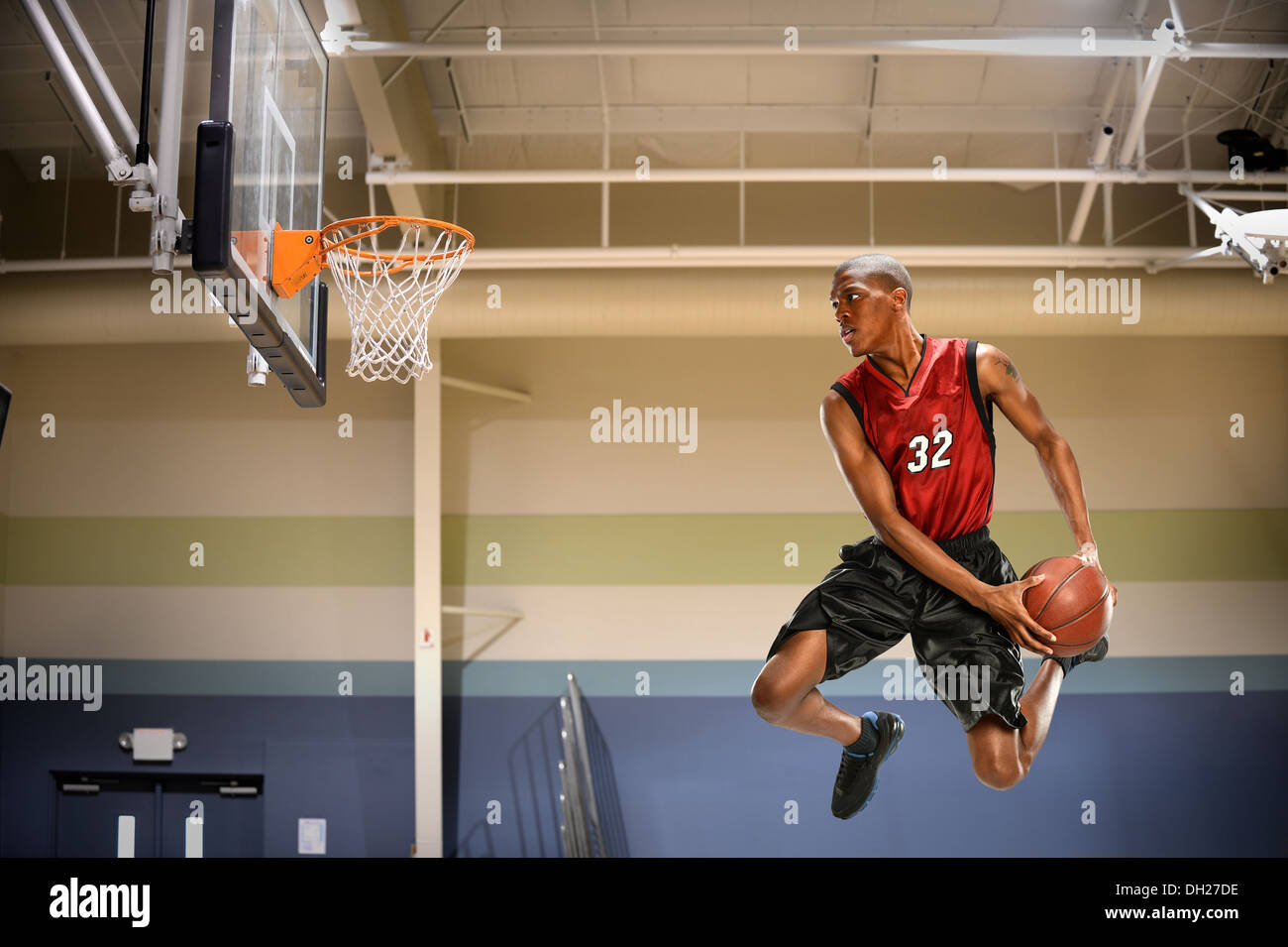 Afrikanische amerikanische Basketballspieler in Aktion in Halle Stockfoto