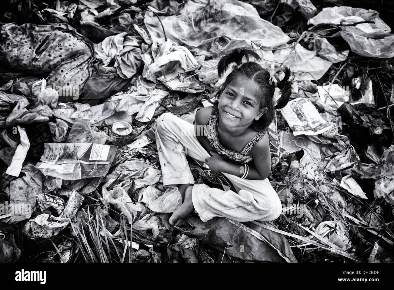 Armen indischen niedriger Kaste Mädchen sitzen in einer Müllhalde. Andhra Pradesh, Indien. Monochrom Stockfoto