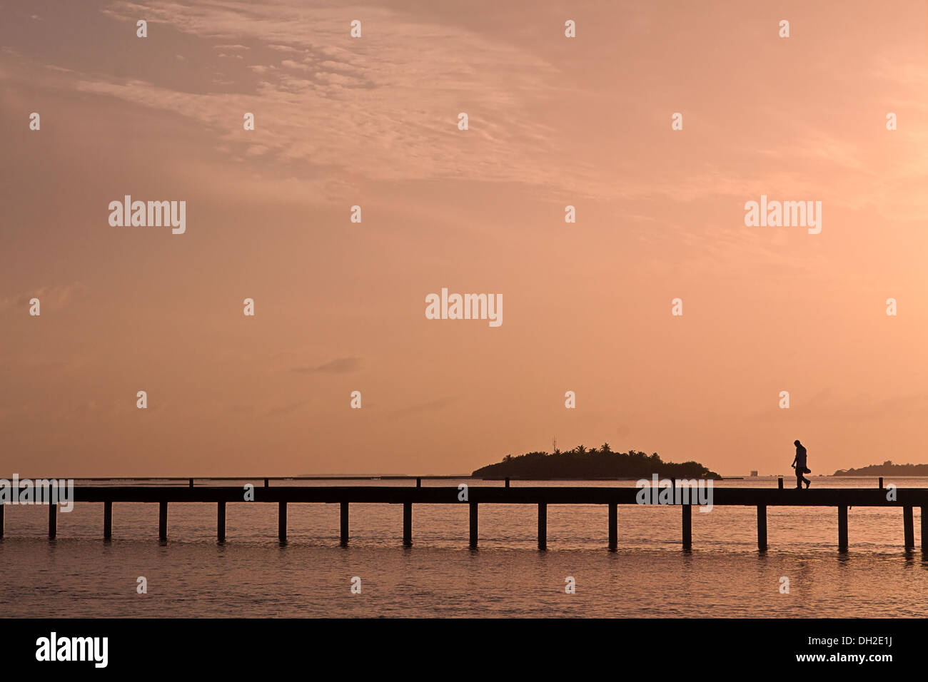 Eine Silhouette Person geht über eine Brücke Stockfoto