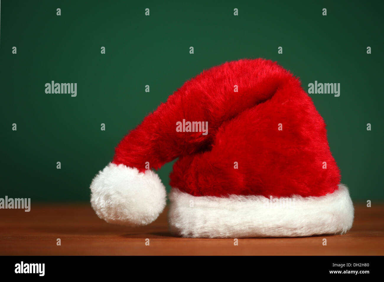 Weihnachtsmann rot Hut mit textfreiraum auf grün und Holz Hintergrund Stockfoto