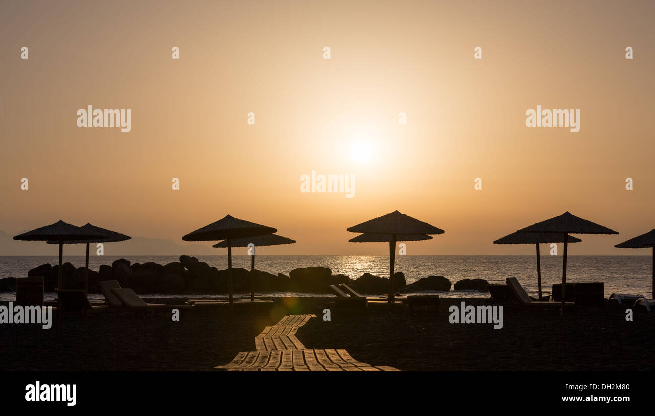 Sonnenschirme am Strand bei Sonnenuntergang Stockfoto