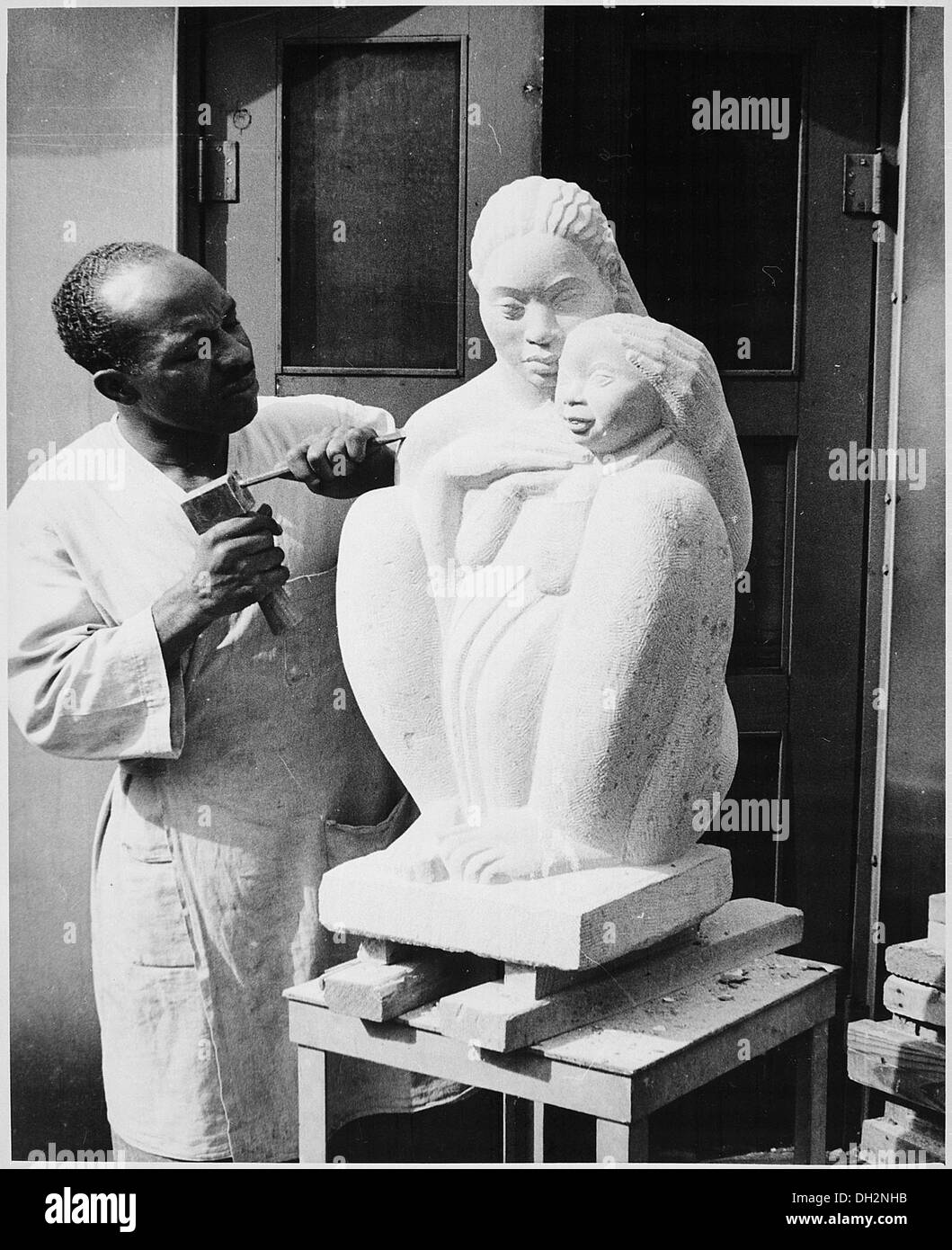 William E. Artis ist auf diesem Foto bei der Herstellung von Töpferwaren zu sehen, die sein Können und seine Kunstfertigkeit in der Keramik widerspiegeln. Artis war bekannt für seine Arbeit in der afroamerikanischen Kunstszene. Stockfoto