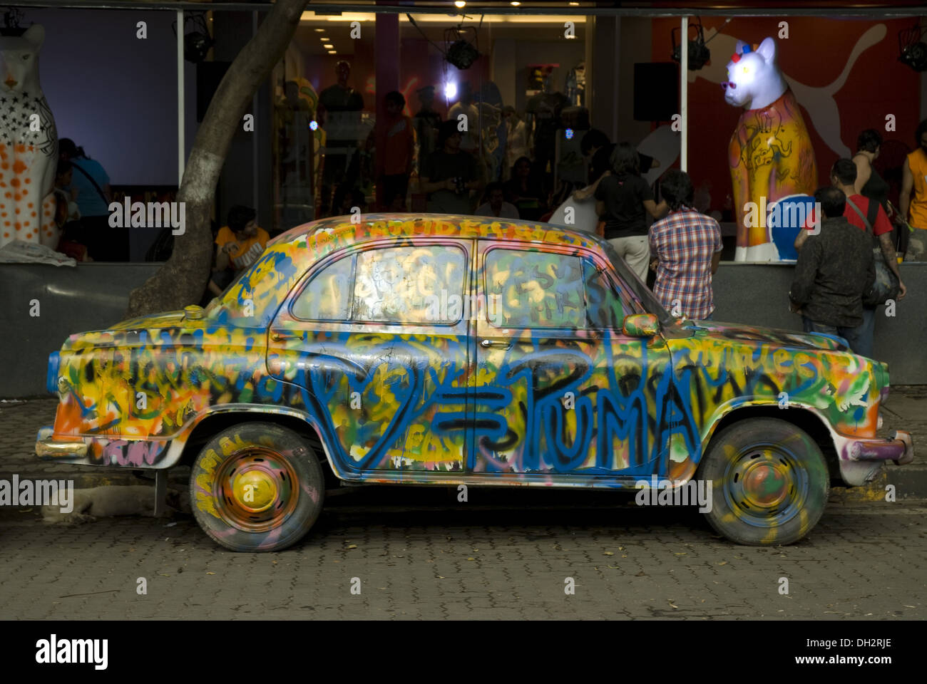 Ambassador-Auto vor dem Geschäft in Linking Road , Khar , Mumbai , Maharashtra , Indien , asien gemalt Stockfoto