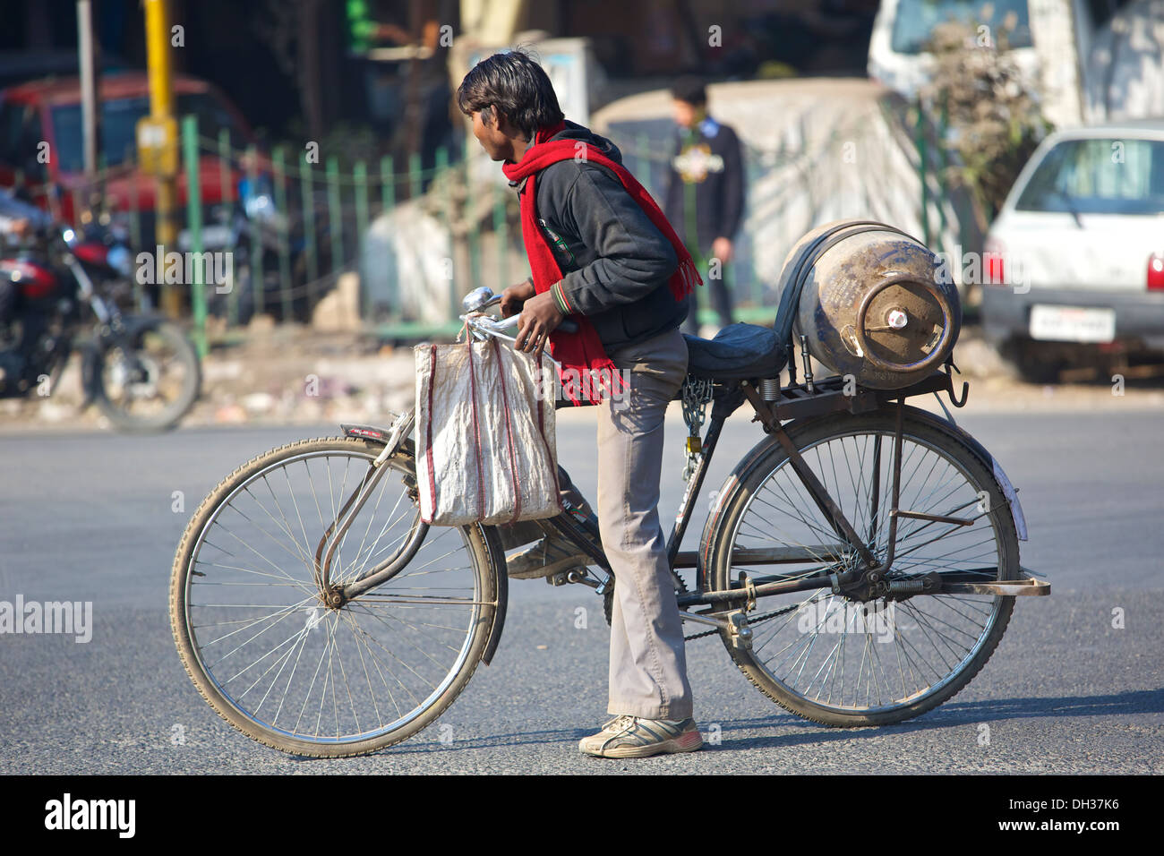 Young indischen Mann trägt A Flasche von Gas auf seinem Fahrrad in Saket, einem Vorort von Delhi, Indien. Stockfoto