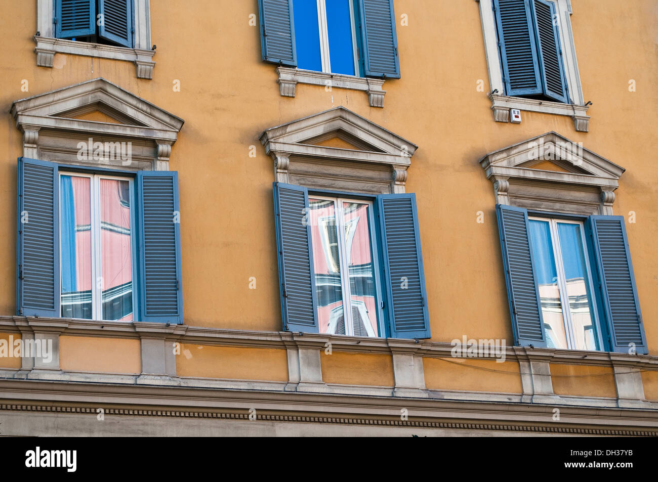 Reflexionen in einem rosa Gebäude in den Witwen der gelben Haus mit blauen Fensterläden, Rom, Italien Stockfoto