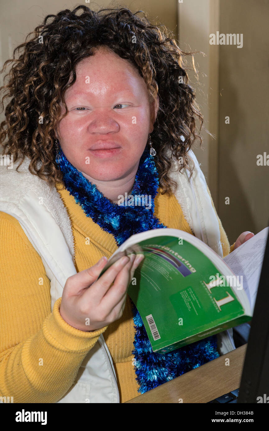 Südafrika, Cape Town. Albino sehbehinderte Schüler halten Arbeitsbuch für Kursteilnehmer. Schule für Blinde in Athlone. Stockfoto