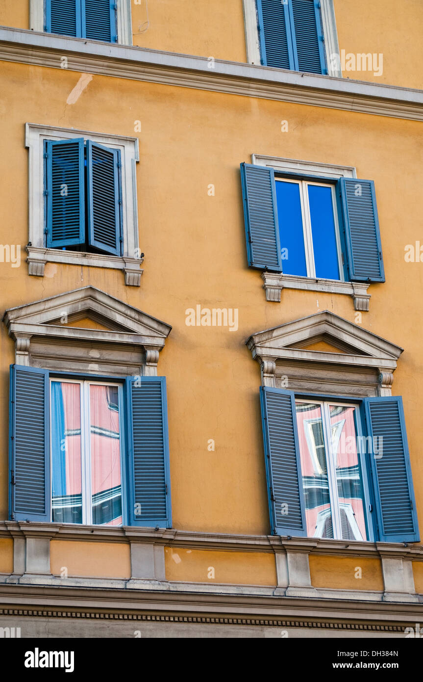 Reflexionen in einem rosa Gebäude in den Witwen der gelben Haus mit blauen Fensterläden, Rom, Italien Stockfoto