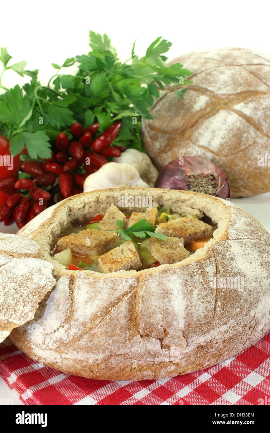 ein Bauernbrot gefüllt mit einer bunten Brotsuppe Stockfoto