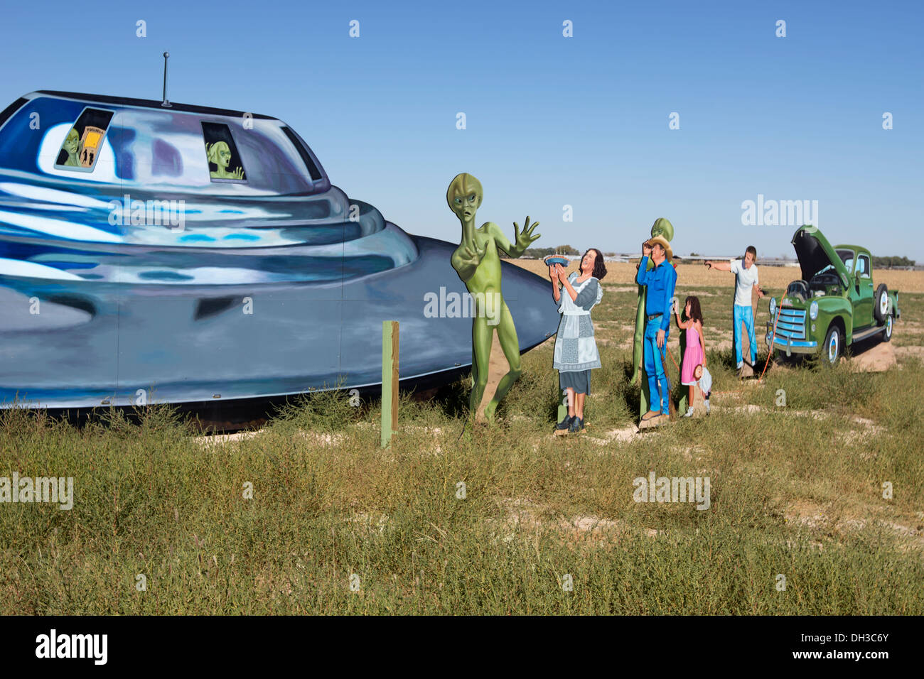 Straßenrand anzeigen Darstellung ein UFO, Aliens und Menschen vor Ort begrüßen sie außerhalb von Roswell, New Mexico. Stockfoto