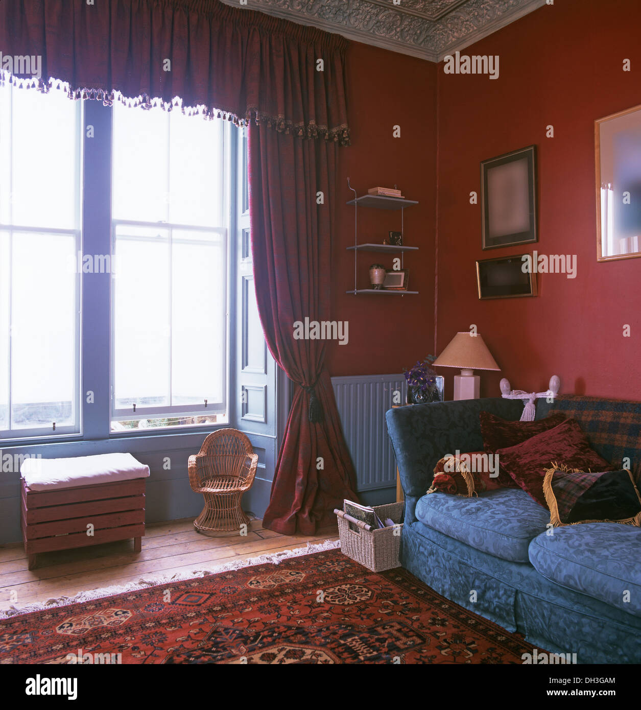 Roten Damast Gardinen und Pelmet am Fenster im roten Wohnzimmer mit blauem  Sofa und gemusterten Teppich Stockfotografie - Alamy