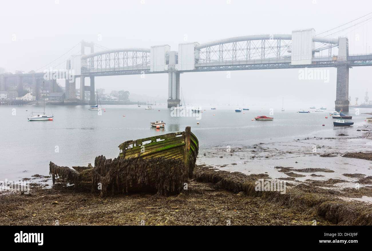 Fäulnis Boot am Ufer des Flusses Tamar mit Royal Albert Bridge als Kulisse an einem nebligen Morgen in Plymouth, Devon UK. Stockfoto