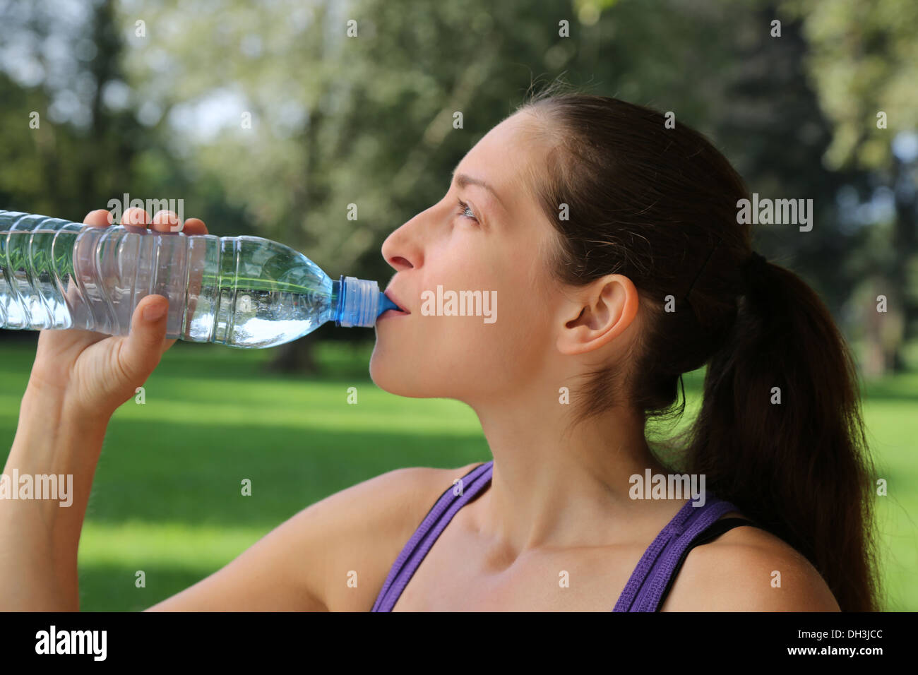 Junge Frau trinkt Wasser aus der Flasche nach dem Sport oder laufen Stockfoto