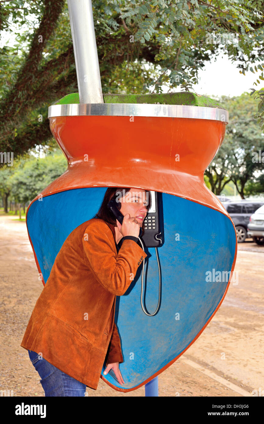 Brasilien, Porto Alegre: Frau mit einem öffentlichen Telefon als traditionelle "Gaúcho" Getränk "Chimarrao" Stockfoto