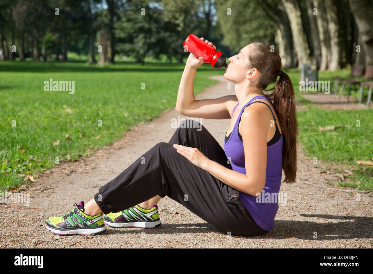 Junge Frau nimmt sich eine Auszeit für Trinkwasser nach Sport oder laufen Stockfoto
