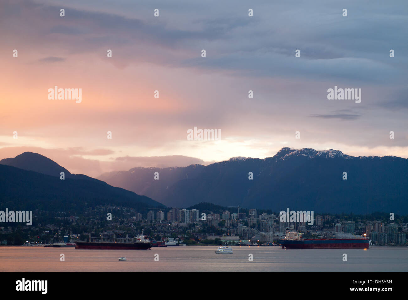Markante Sonnenuntergang über Vancouver Harbour, North Vancouver und Grouse Mountain gesehen von der Innenstadt von Vancouver, BC, Kanada. Stockfoto