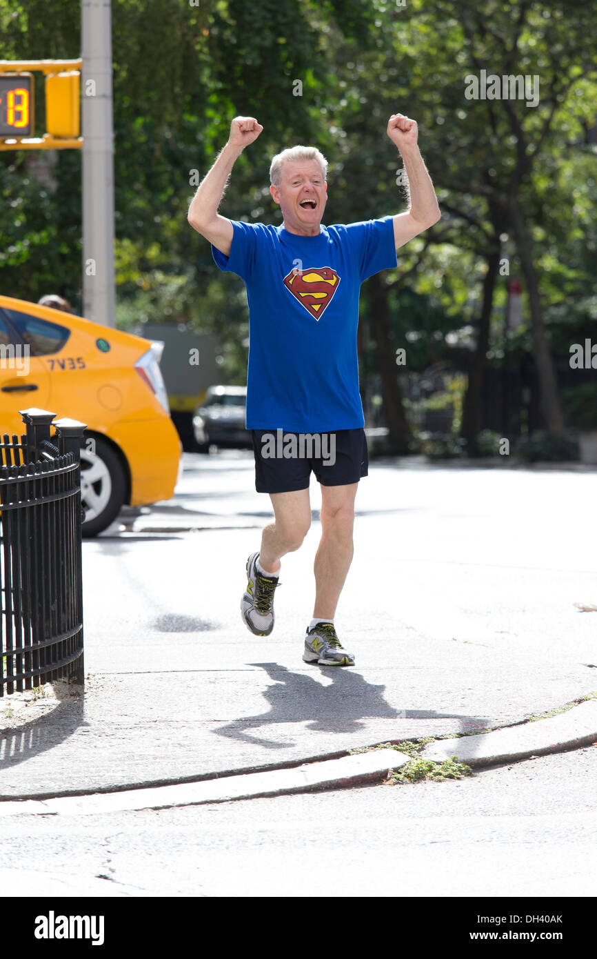 Siegreiche Senior woman Joggen auf Stadtstraßen mit Superman T-Shirt, NYC Stockfoto