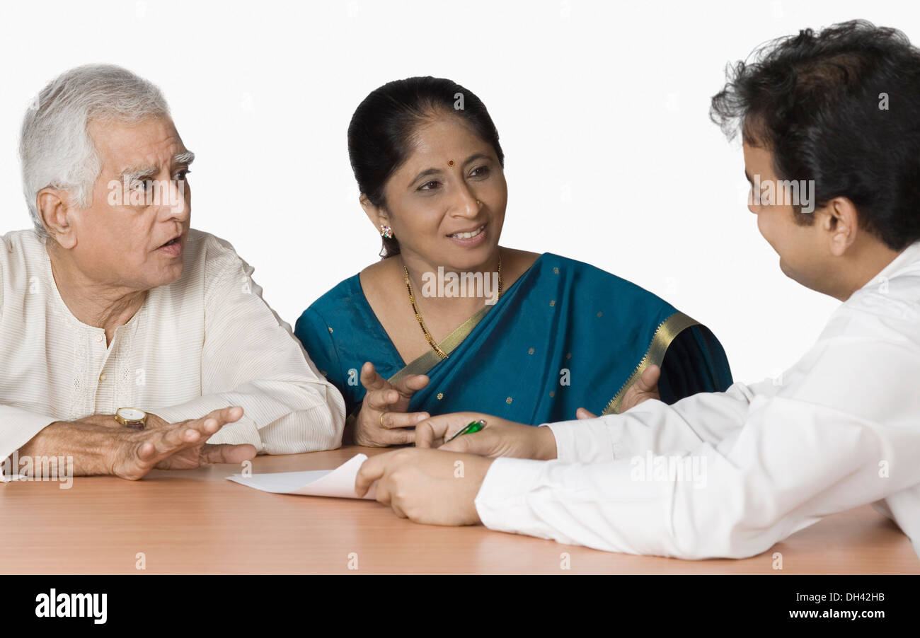 Paar diskutieren mit einem Finanzberater Stockfoto