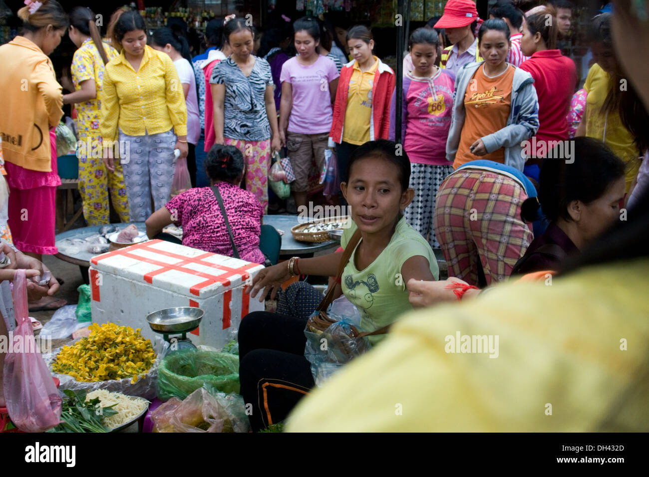 Frauen, die am nahe gelegenen Textilfabriken Arbeiten sind nach ihrer Schicht in Phnom Penh, Kambodscha Lebensmittel auf dem Markt kaufen. Stockfoto