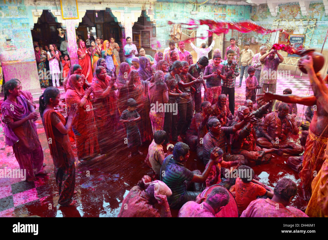 Holi Indianerfest der Priester gießt Farben nass Farbe auf Anhänger Ghanshyam Tempel Jodhpur Rajasthan Indien Asien Stockfoto