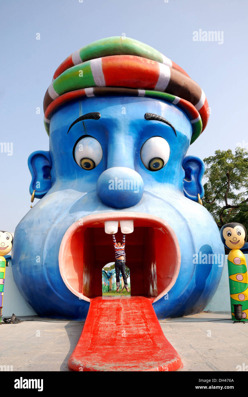 junge hängen von den Zähnen des großen Mund Spaß Spielzeug in Hyderabad, Andhra Pradesh, Indien Stockfoto