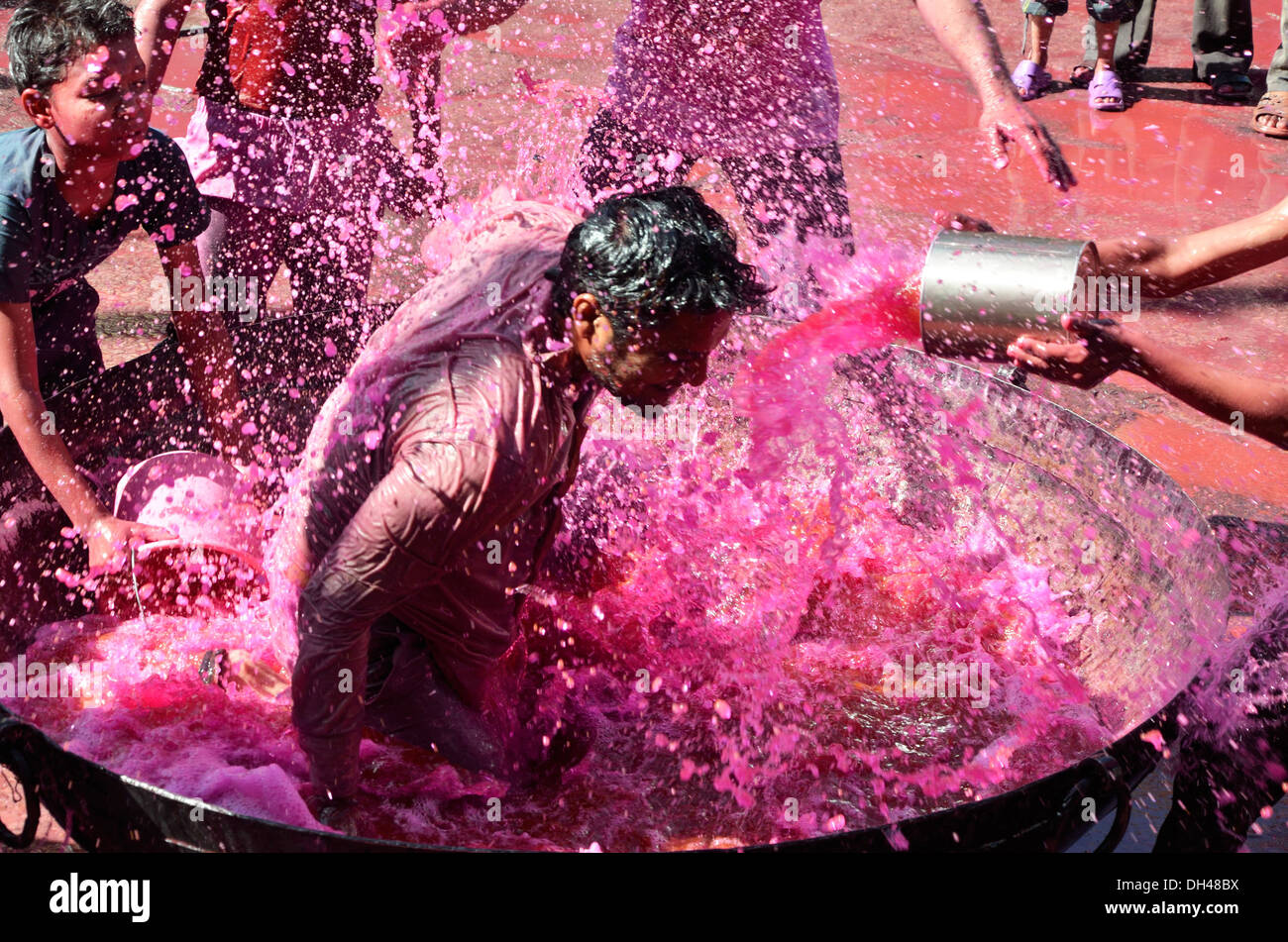 Junge in Bottich voll Farbe Wasser auf Holi Festival Jodhpur, Rajasthan Indien Asien Stockfoto