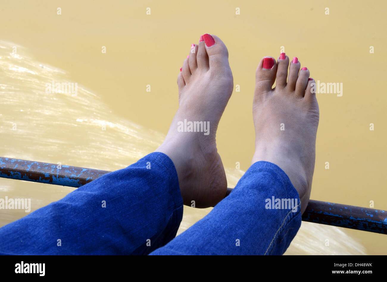 Frau Blau Jeans trocknen ihre Füße roten Nagellack Flusses Godavari  Rajahmundry Andhra Pradesh, Indien Stockfotografie - Alamy