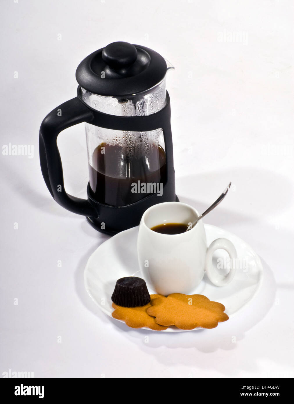 Kaffee, traditionelle französische Presse Kaffeemaschine und kleine weiße Tasse mit einem silbernen Löffel, Kekse und Schokolade. Stockfoto