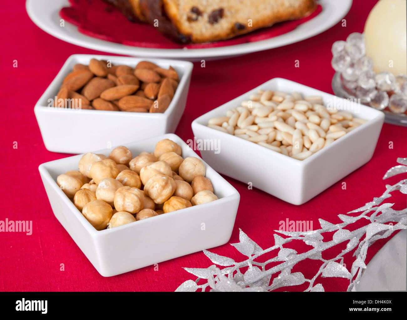 Pinienkernen, Mandeln und Haselnüsse in Schüsseln auf dem Weihnachtstisch. Stockfoto