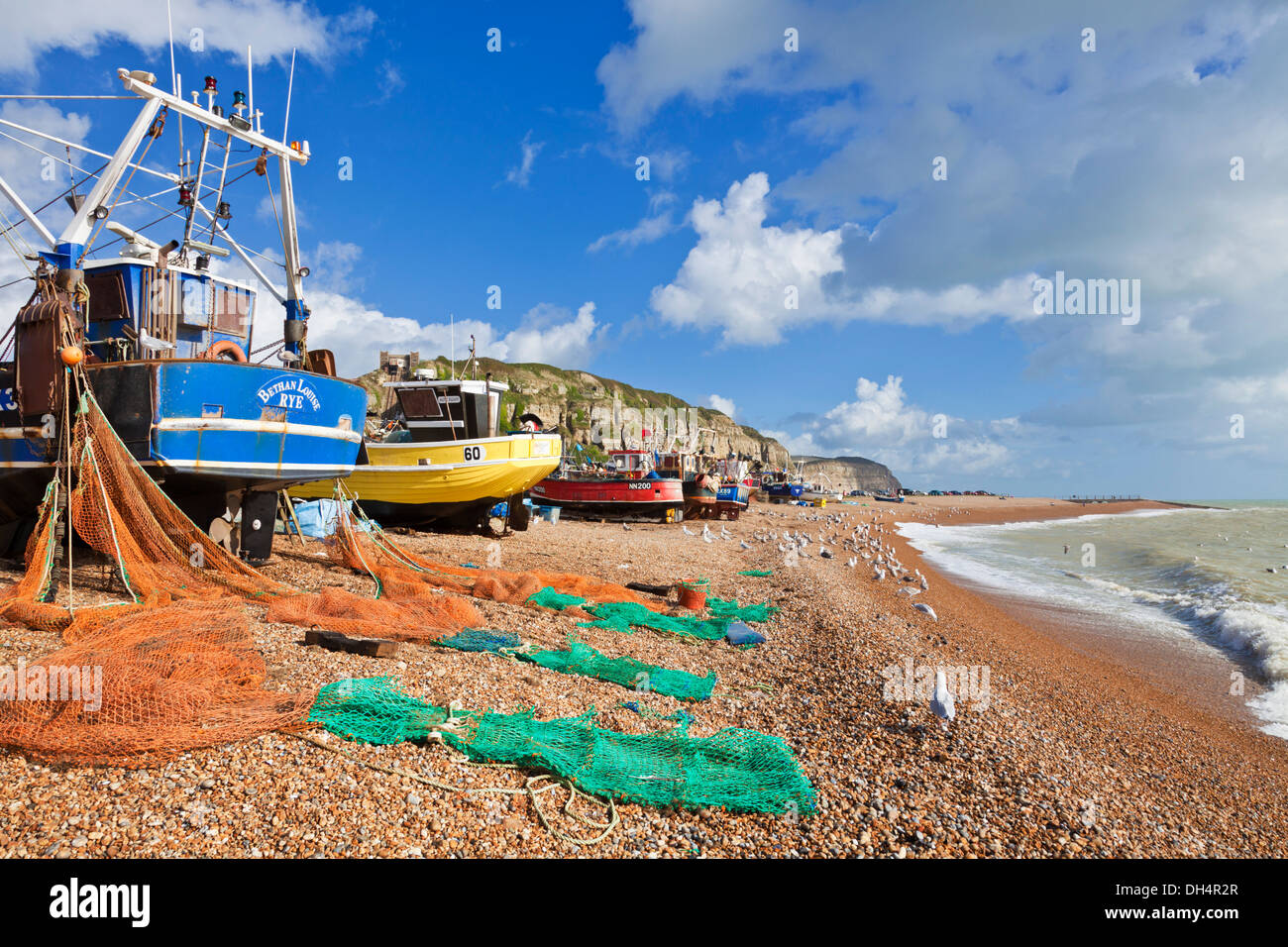 Fischerboote, die Netze trocknen, wurden am Strand von Hastings East Sussex England GB UK Europe hochgezogen Stockfoto