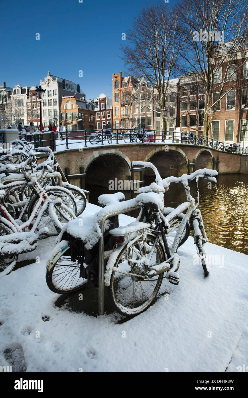 Die Niederlande, Amsterdam, Canal Häuser im Kanal Singel genannt. UNESCO-Weltkulturerbe. Fahrräder. Winter, Schnee Stockfoto