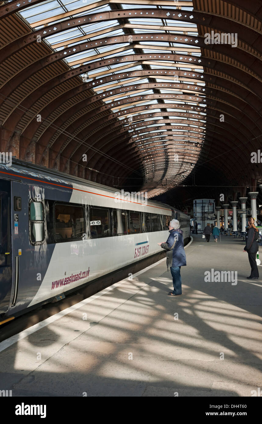 Die Leute auf dem Bahnsteig und der Ostküstenzug bereiten sich darauf vor, den Bahnhof zu verlassen York North Yorkshire England UK Vereinigtes Königreich GB Großbritannien Stockfoto