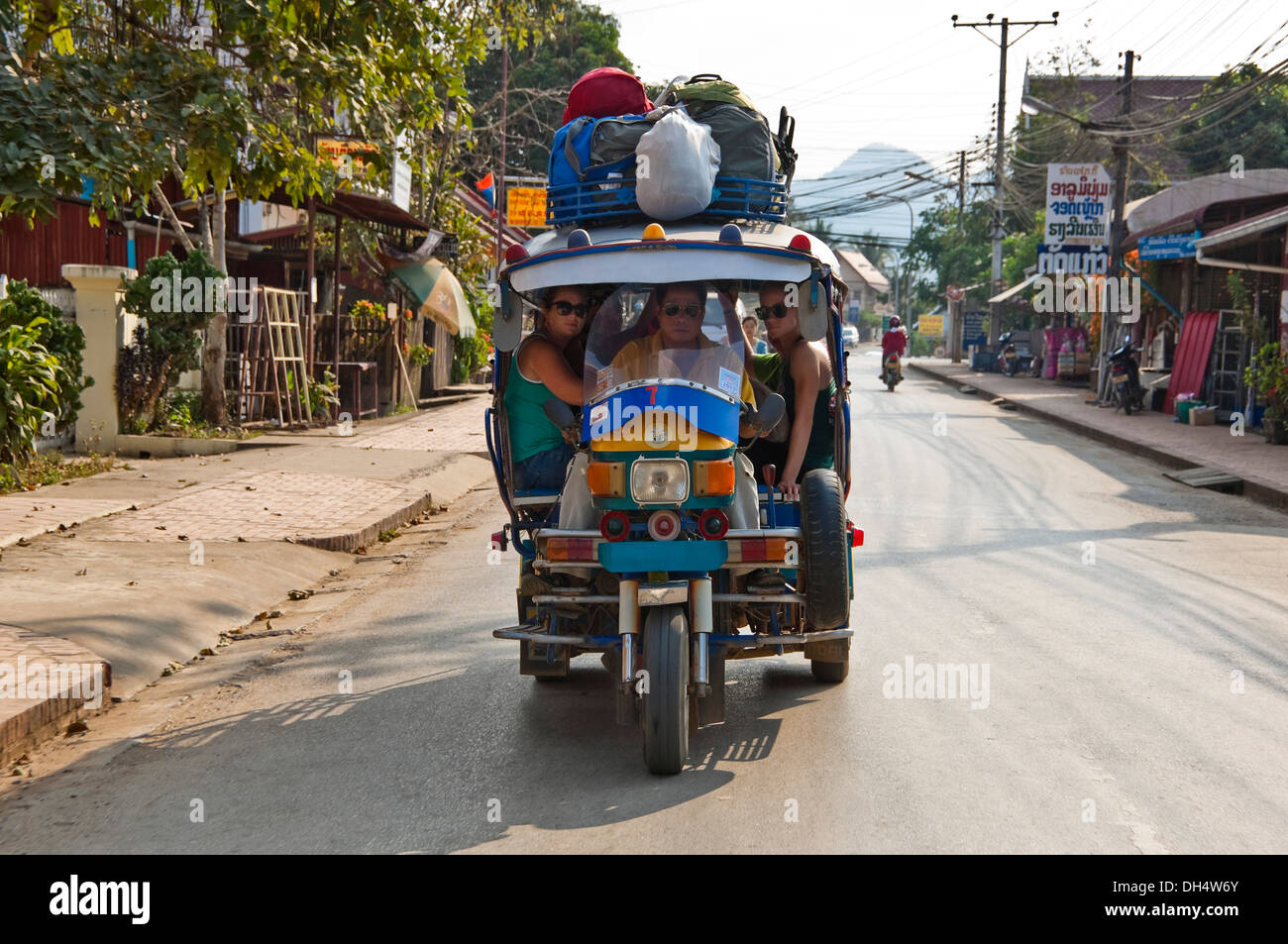 Horizontale Nahaufnahme von einem Jumbo Tuk-Tuk mit Touristen an Bord in Luang Prabang. Stockfoto