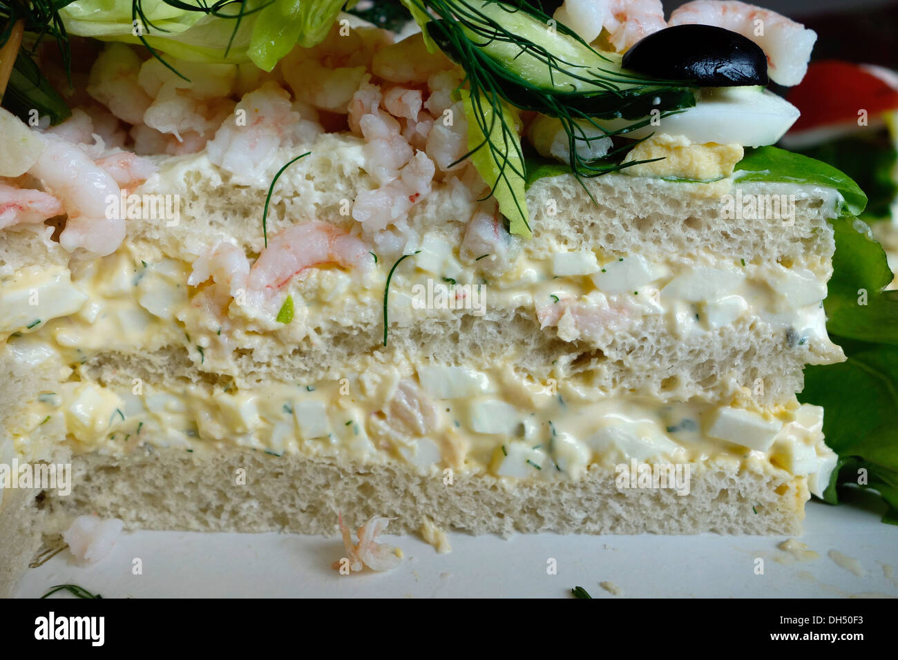 Cross-Cut Stück Smörgåstårta oder Sandwich-Kuchen. Eine herzhafte skandinavische Küche Speise. Stockfoto
