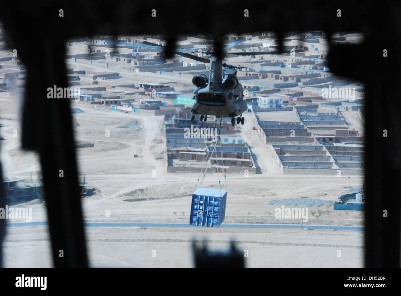 Die Aussicht auf einen 10. Combat Aviation Brigade CH-47 Chinook Hubschrauber Schlinge Laden gesehen ein Versandbehälter aus dem cockpit Stockfoto