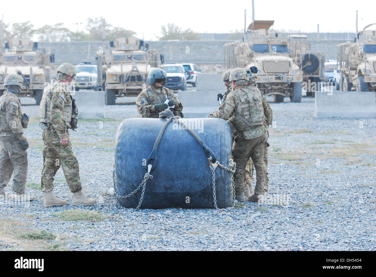 Sgt. Daniel Glenn, CH-47 Chinook Hubschrauber Flugingenieur aus Texas National Guard, im Rahmen der 10. Combat Aviation Brigade, bespricht Schlinge Last Strategie mit Mitgliedern der E Company, 3. Bataillon (allgemeiner Support), 10. CAB, vor der Schlinge Stockfoto