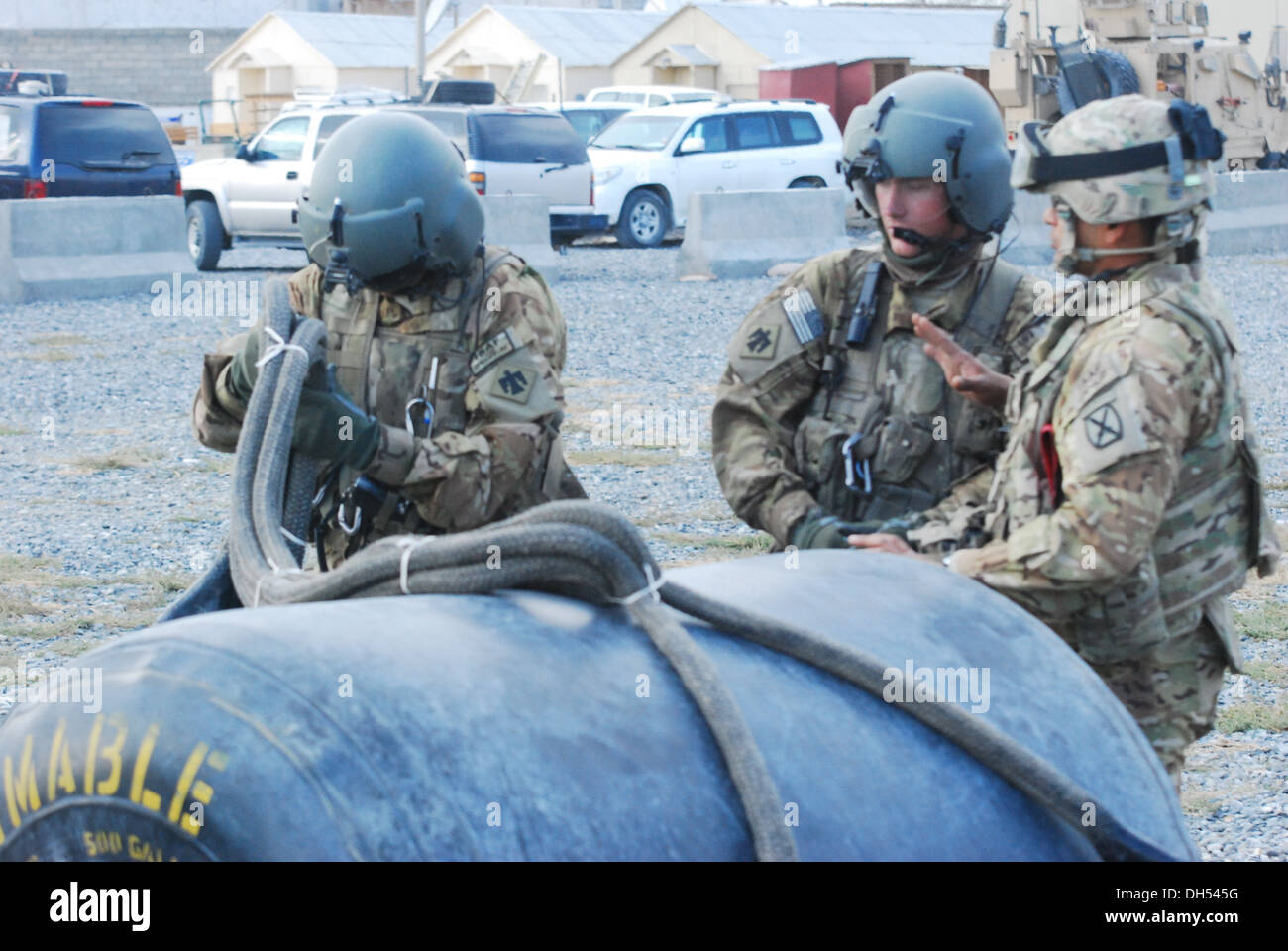 Sgt. Daniel Glenn, Crewchief von der Texas National Guard Umhüllung unter 10. Combat Aviation Brigade, inspiziert die Takelage verwendet Schlinge Belastung 500 Gallonen Kraftstoff Container bei einem Sprung vorwärts Bewaffnung und Tankstellen ausüben 26. Okt. um vorwärts Stockfoto