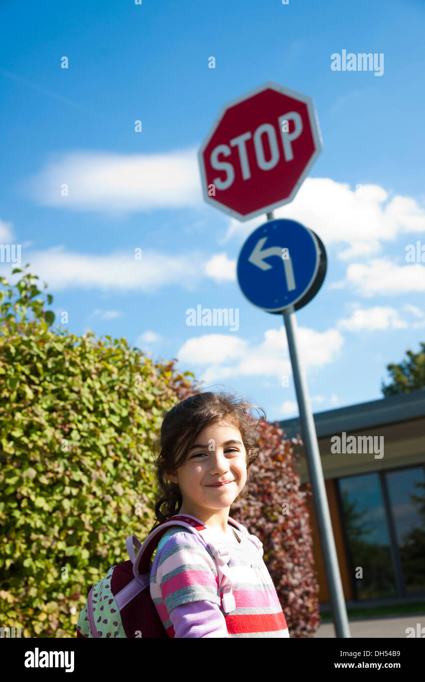 Mädchen stehen neben einem Stop-Schild Stockfoto