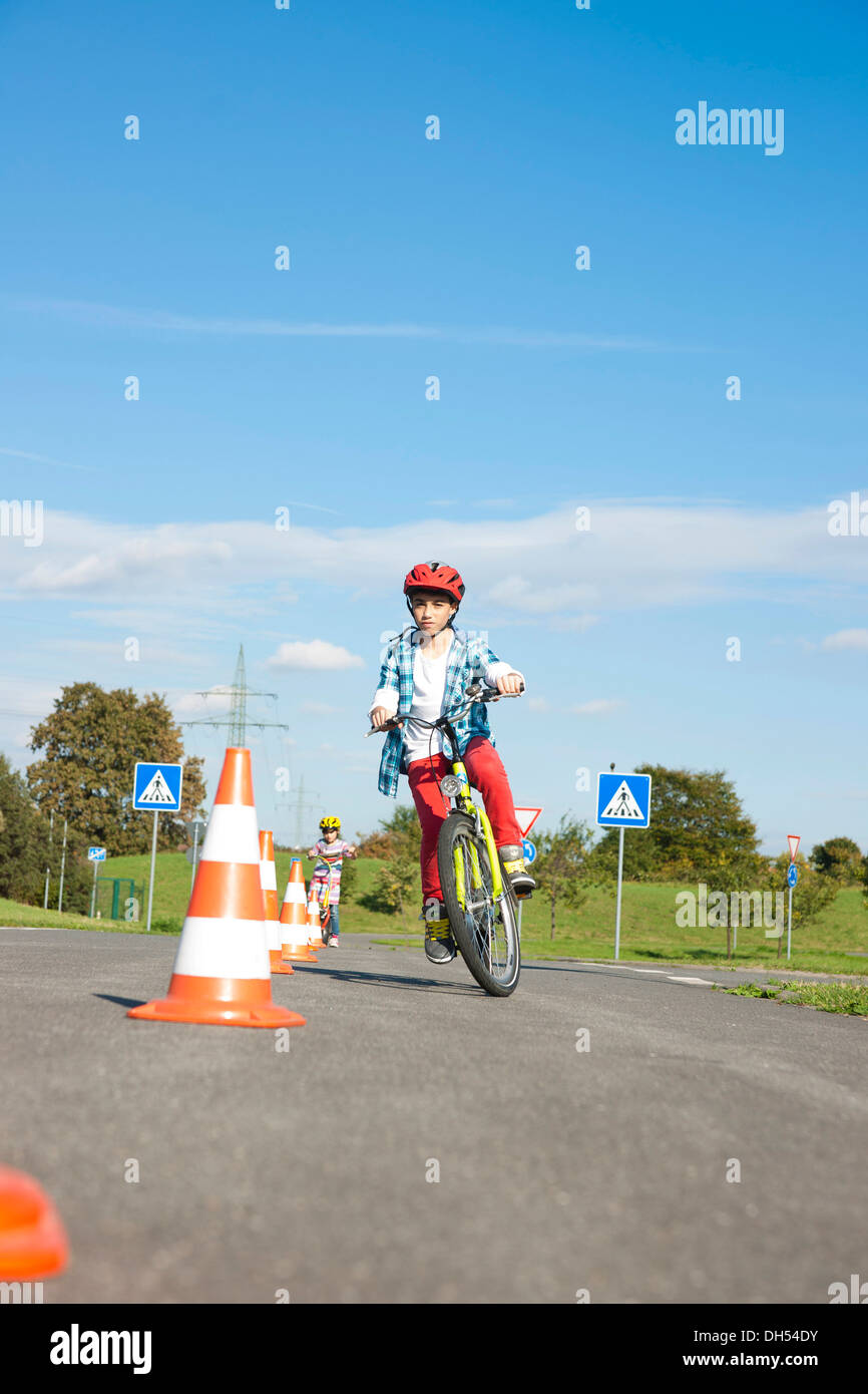 Kinder üben, um Slalom fahren auf einem Fahrrad bei einem Verkehrs-Bewusstsein-Kurs Stockfoto