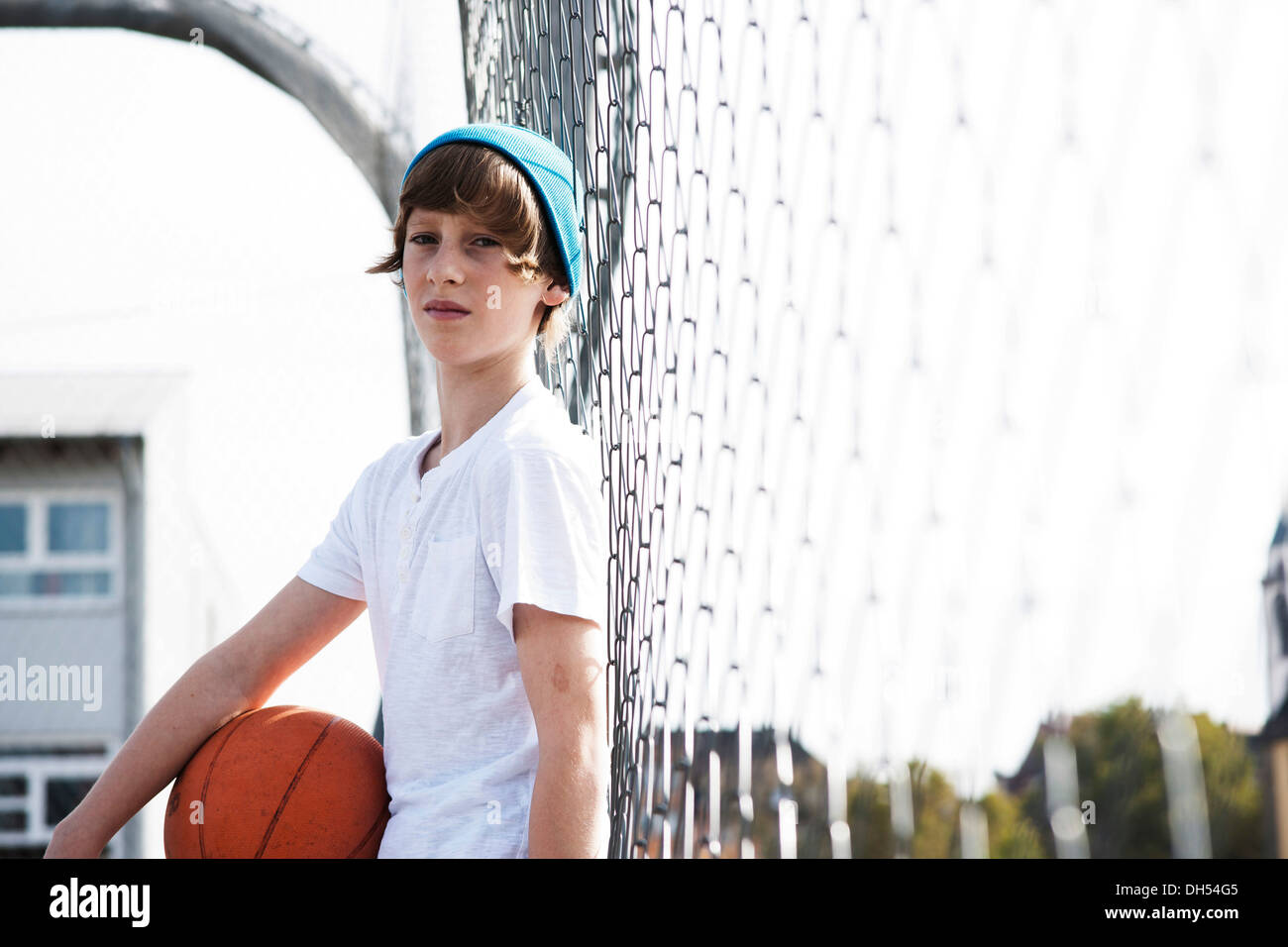 Coole junge hält einen basketball Stockfoto