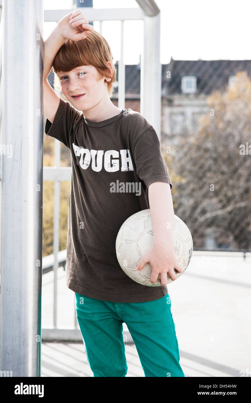 Coole junge hält einen Fußball Stockfoto