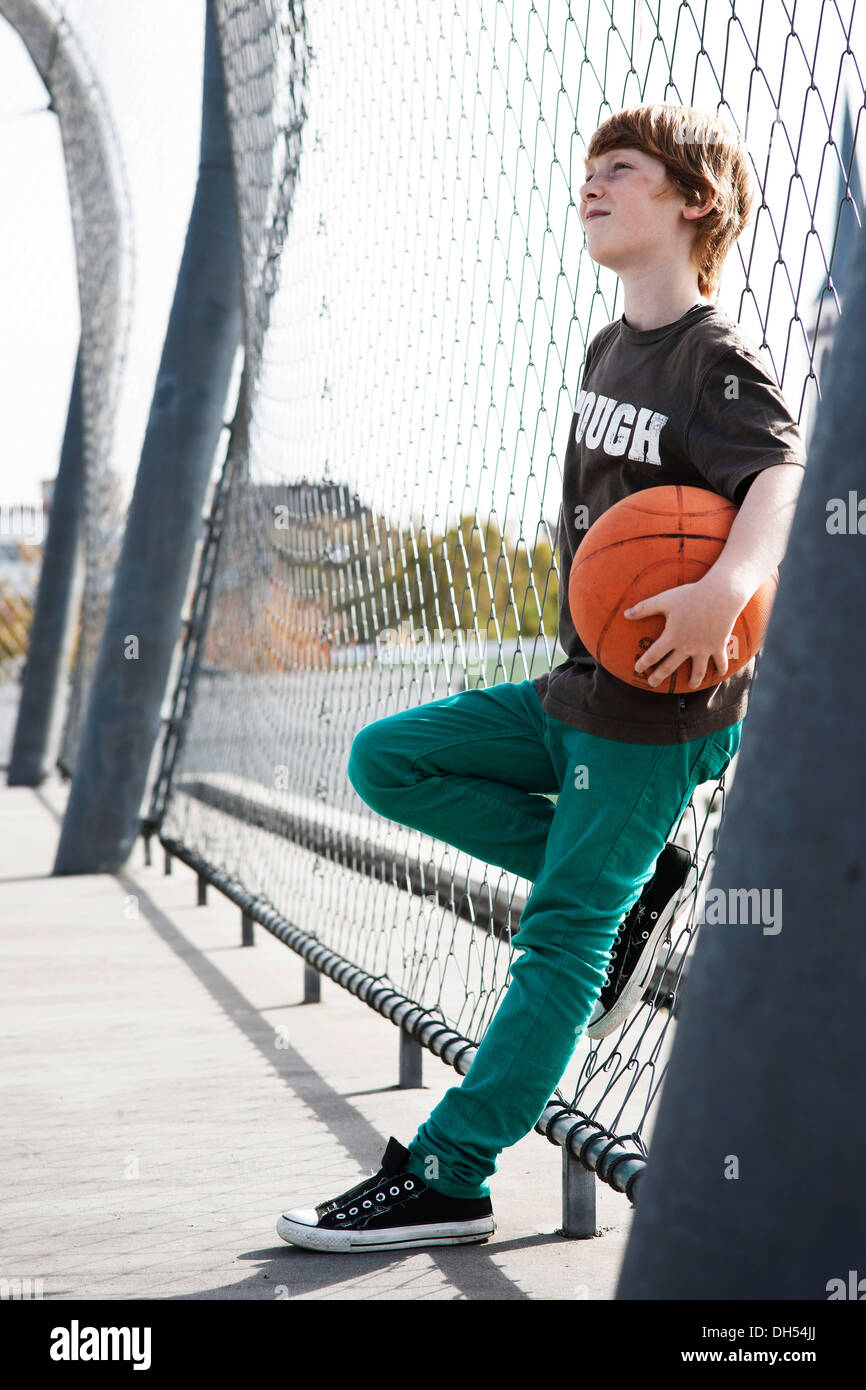 Coole junge hält einen basketball Stockfoto