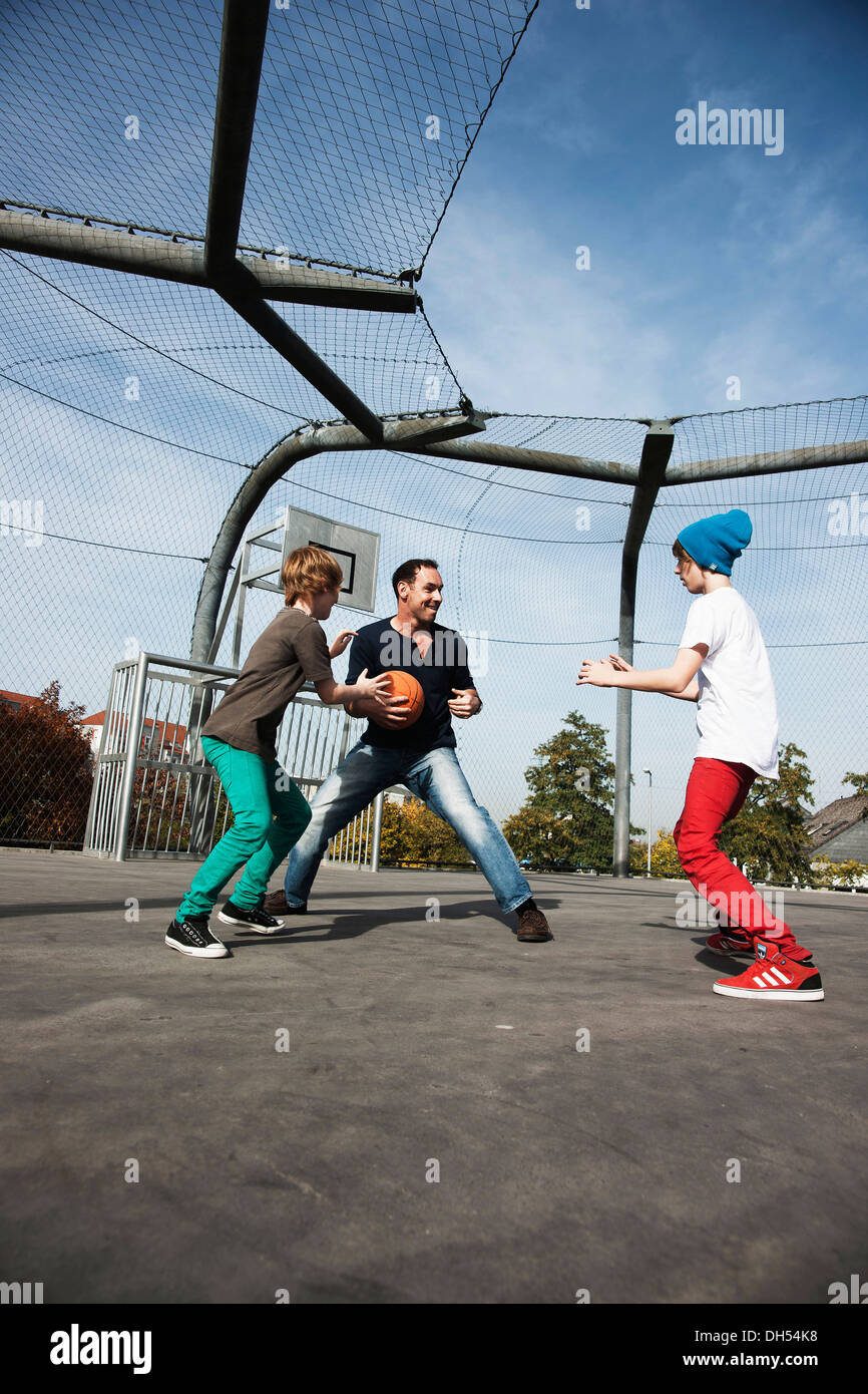 Zwei coole Jungs Basketball spielen mit ihrem Vater Stockfoto