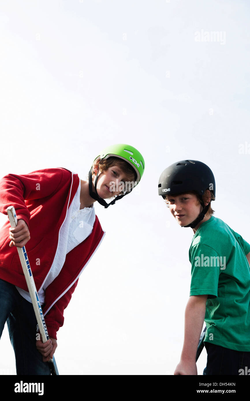 Zwei coole Jungs spielen Rollhockey mit Hockeyschläger Stockfoto